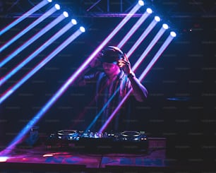 a dj mixing on a stage with a lot of lights