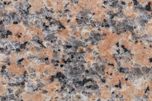 a close up of a marble surface with orange and black colors