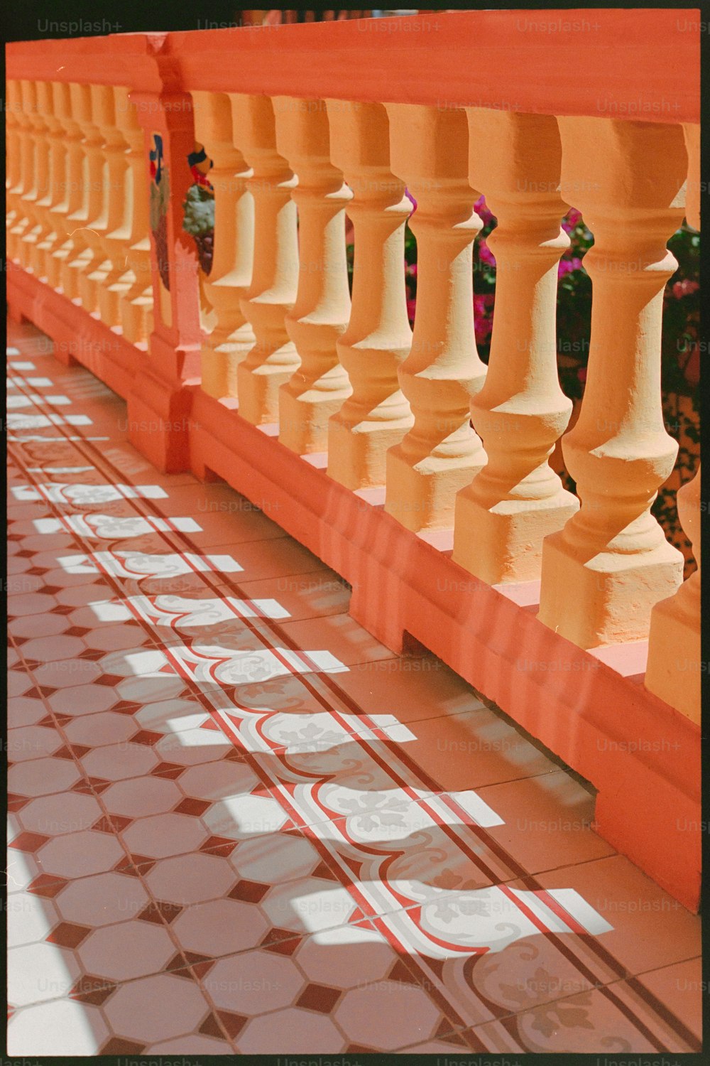 a row of orange and white pillars on a tiled floor