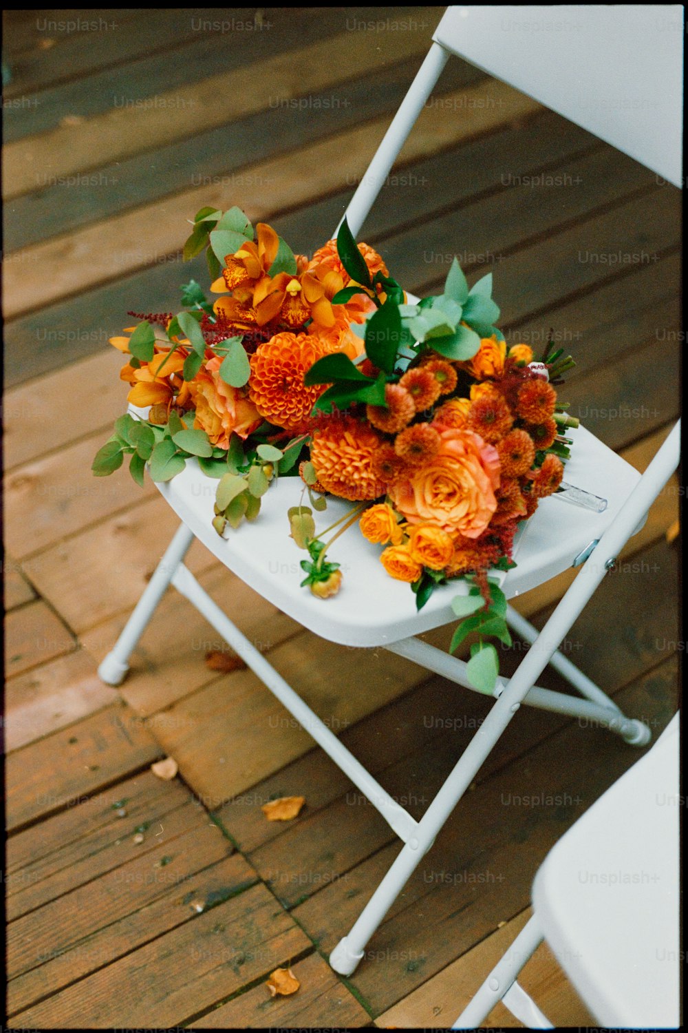 a white folding chair with a bouquet of flowers on it