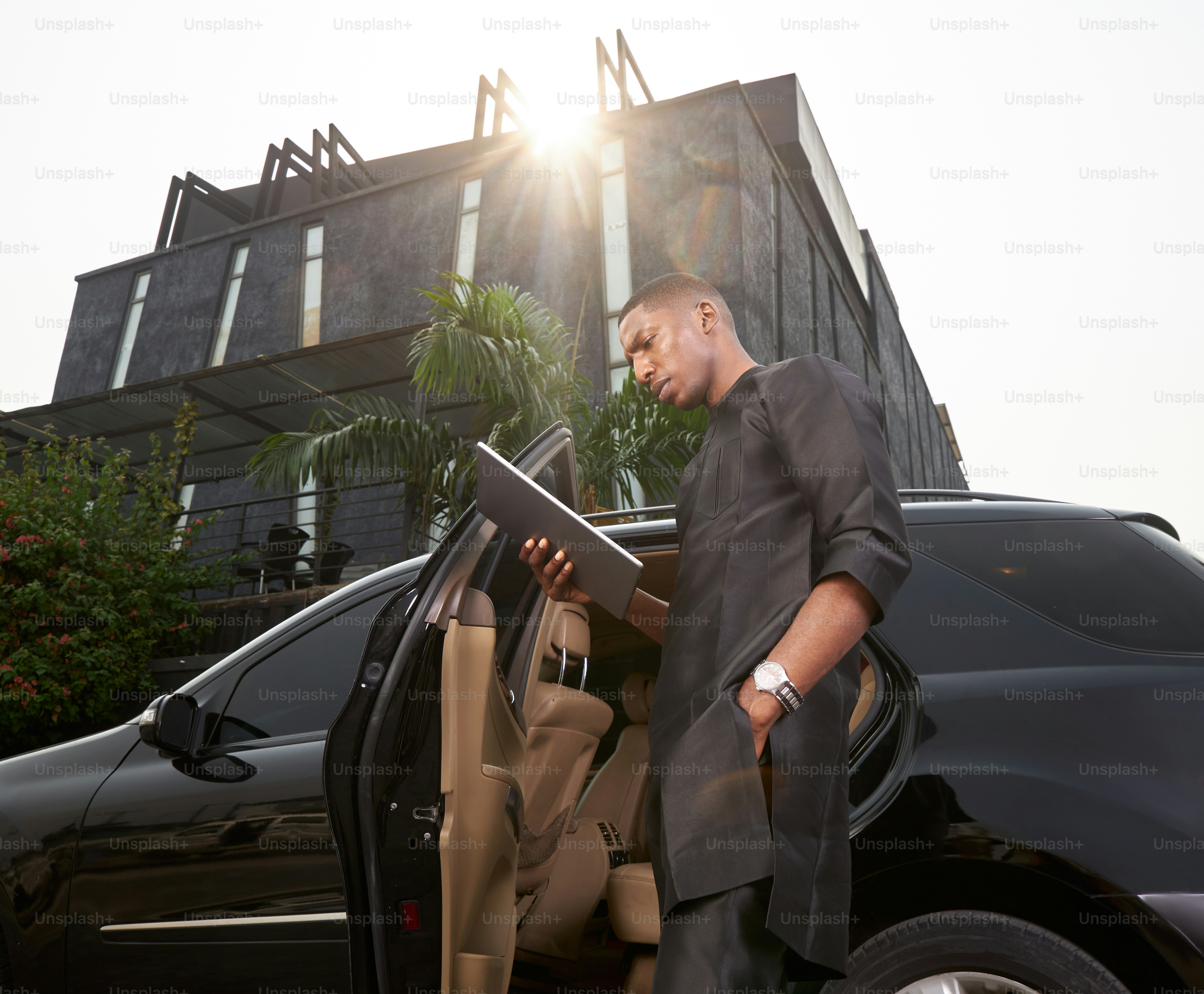 ein Mann, der in der offenen Tür eines Autos steht