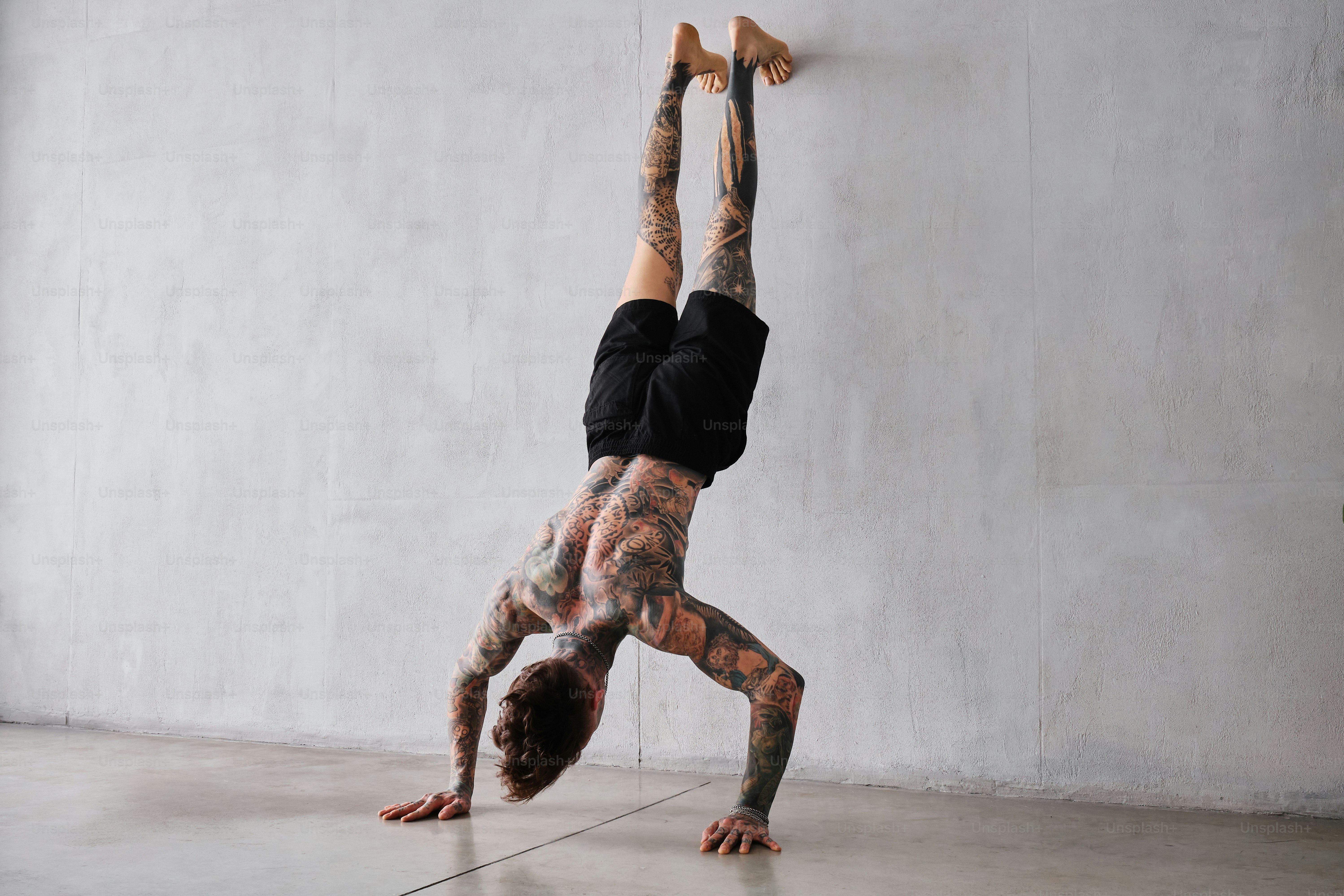 部屋で逆立ちをする男