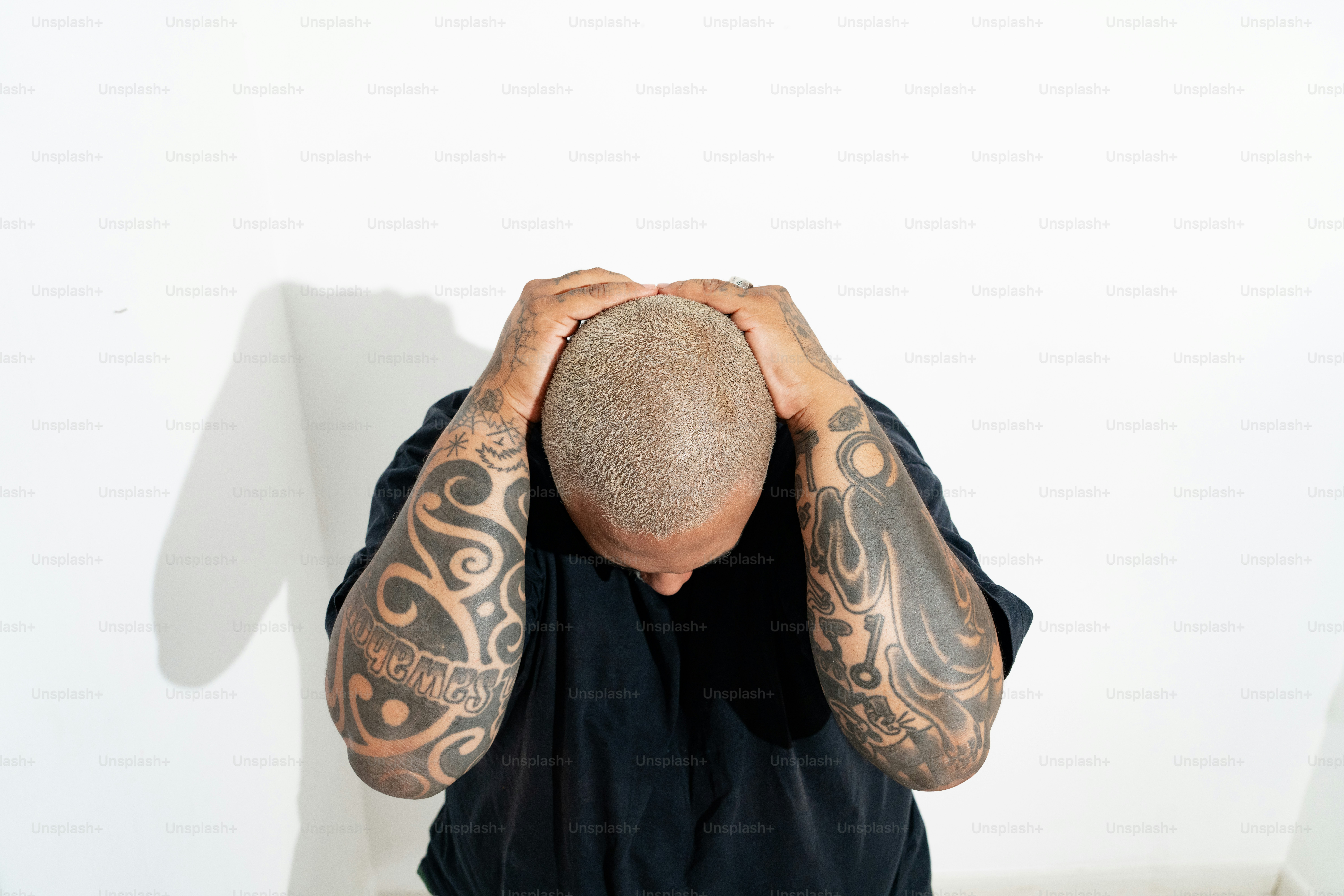a man covering his face with his hands