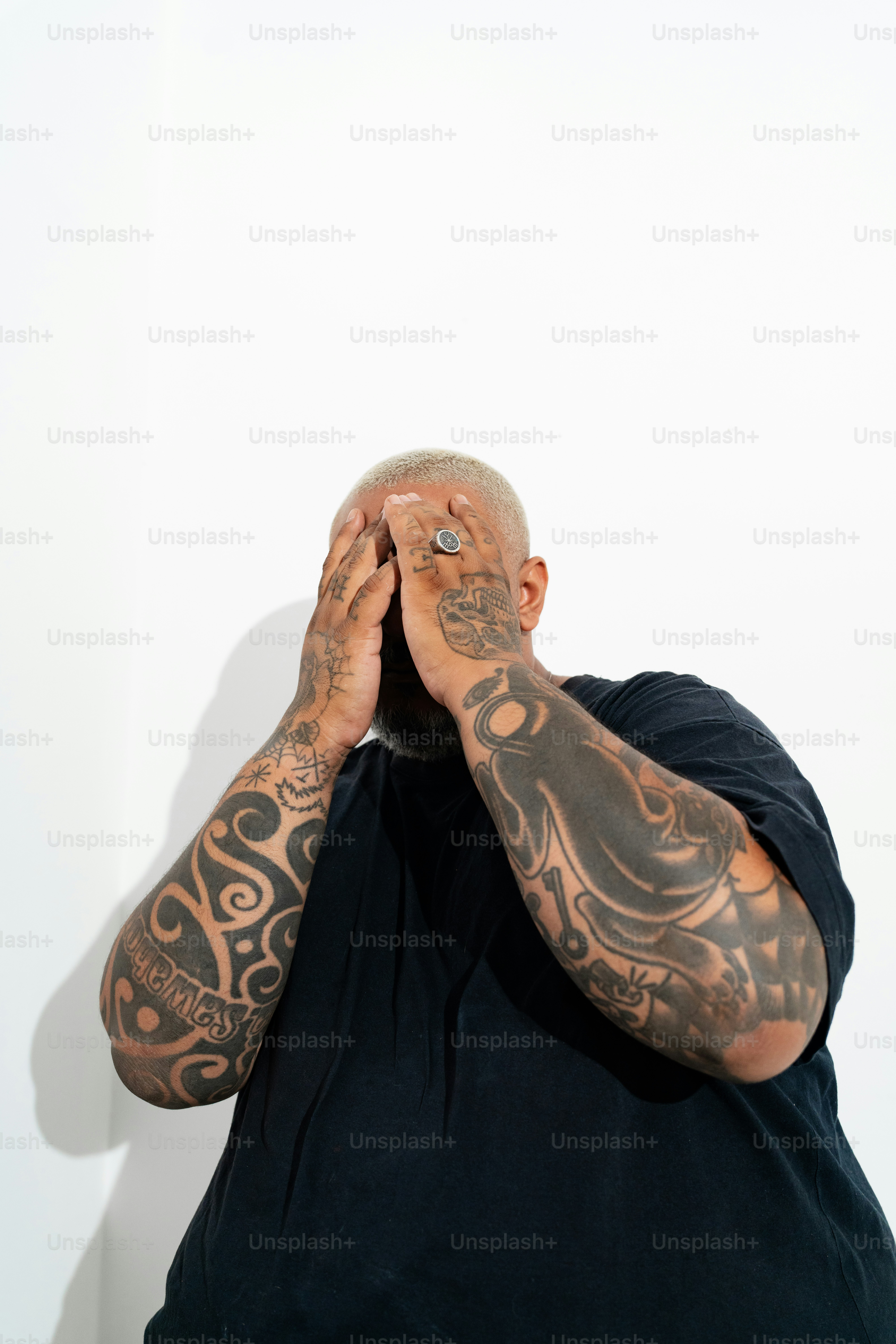 a man covering his face with his hands