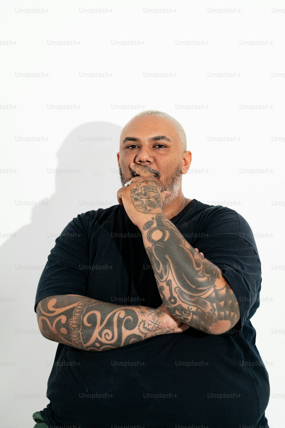 a man with tattoos on his arms posing for a picture