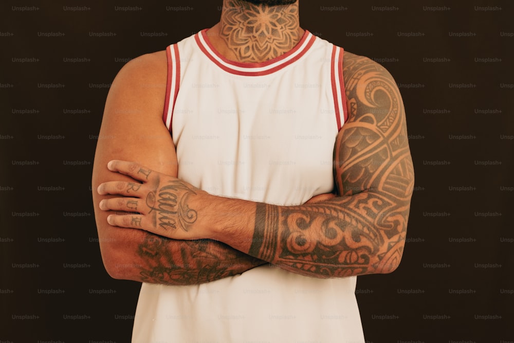un homme avec des tatouages sur les bras et la poitrine