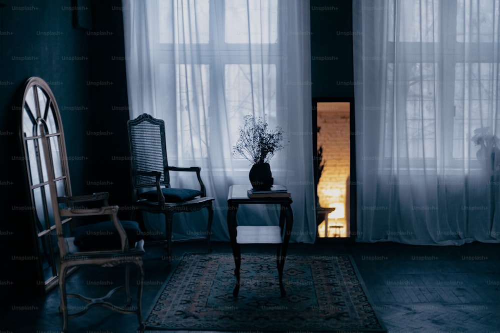 uma sala escura com uma cadeira e uma mesa com um vaso sobre ela