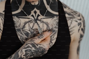 uma mulher com tatuagens segurando um cigarro na mão