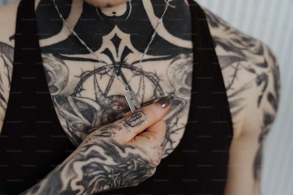a woman with tattoos holding a cigarette in her hand