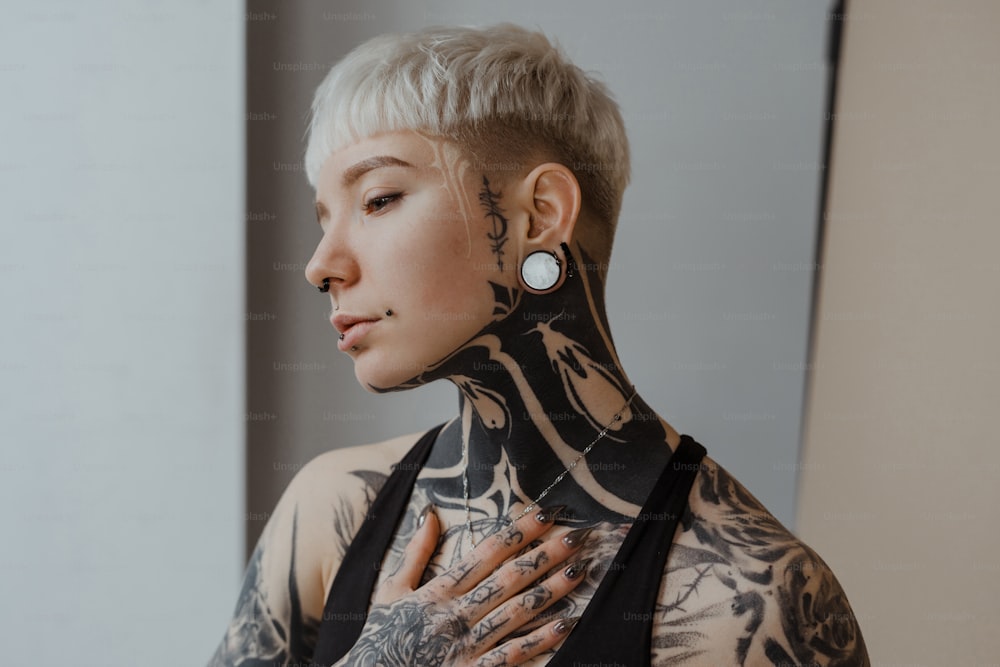 a woman with tattoos and piercings on her neck