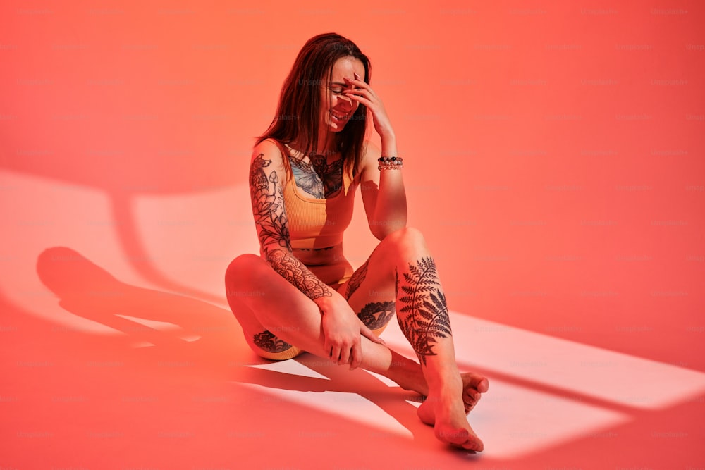 une femme tatouée assise sur le sol