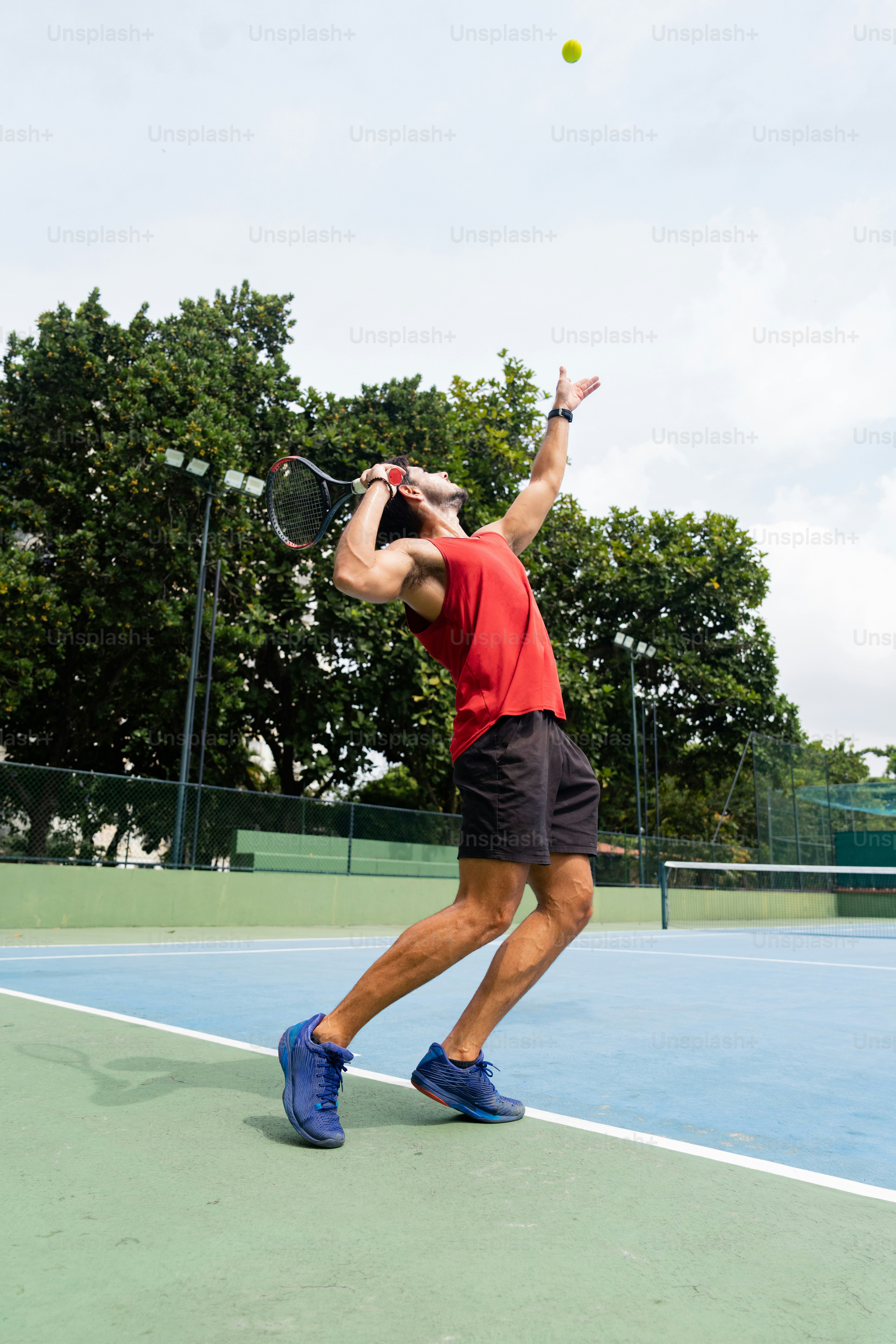 un uomo che fa oscillare una racchetta da tennis su una pallina da tennis