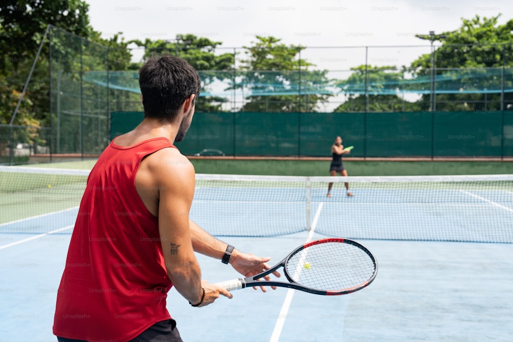 um homem segurando uma raquete de tênis em uma quadra de tênis