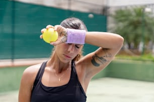a woman holding a tennis ball in her hand
