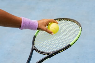 a person holding a tennis racket and a tennis ball