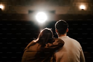 a man and a woman standing in front of a light