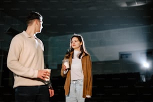 Ein Mann steht neben einer Frau mit einem Getränk in der Hand