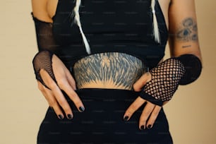 eine Frau in einem schwarzen Kleid, die ihre Hände in die Hüfte stemmt