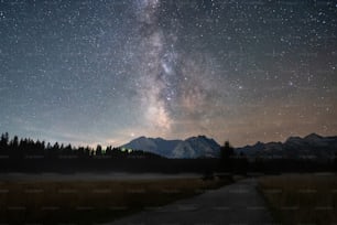 the milky shines brightly over the mountains in the distance