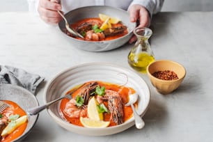 a person is eating a bowl of seafood soup