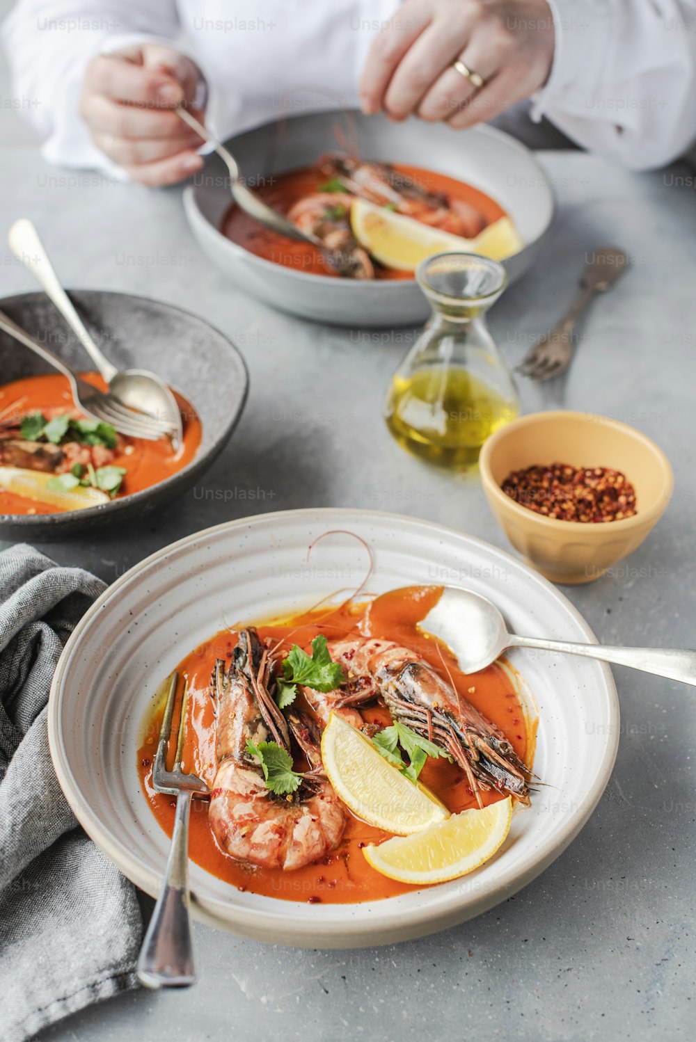 a bowl of soup with shrimp and garnishes