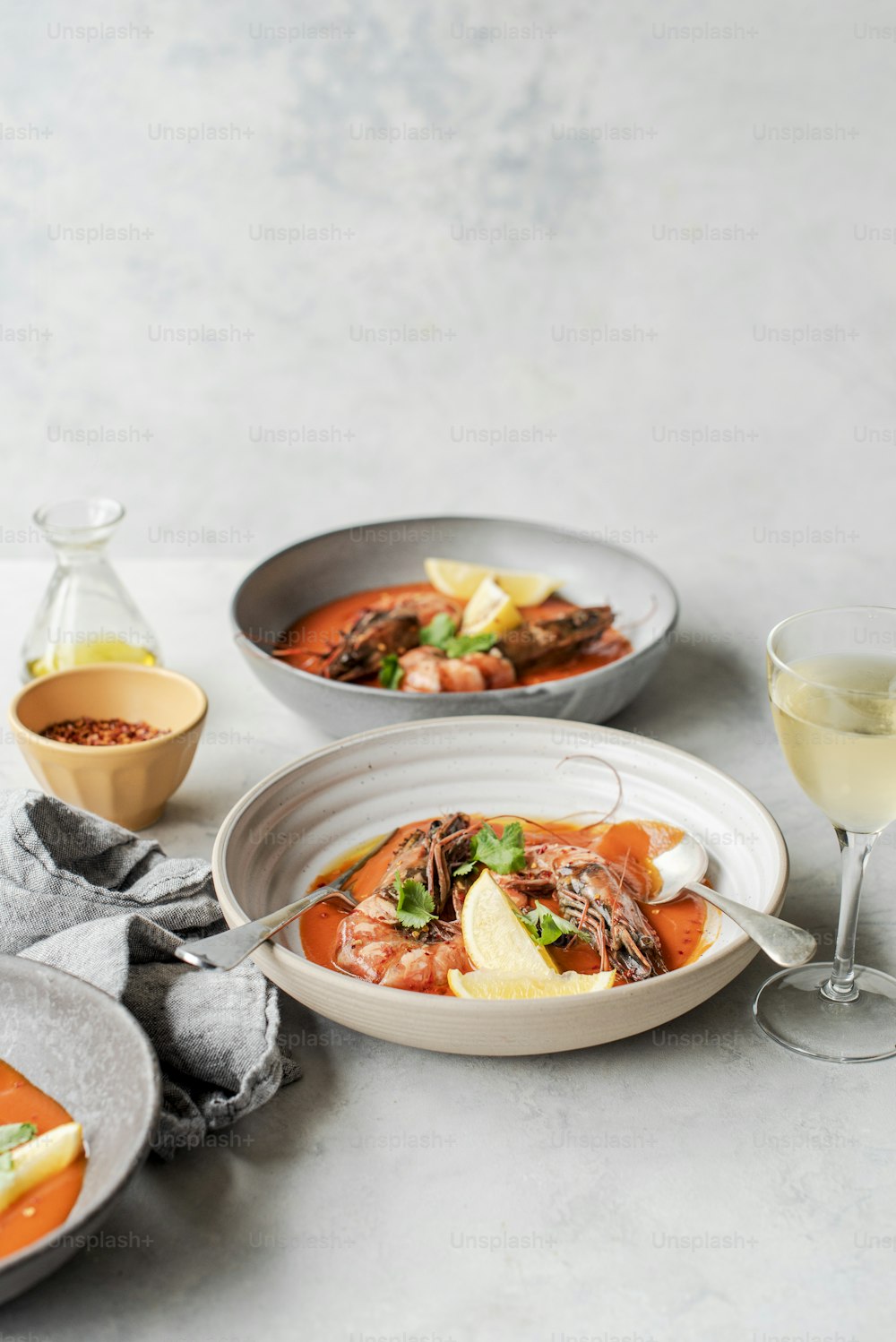 una mesa cubierta con platos de comida y una copa de vino