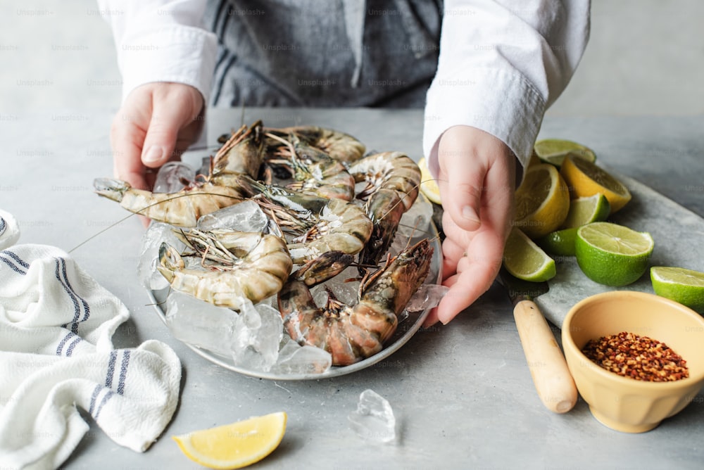 a person cutting up some shrimp on a plate