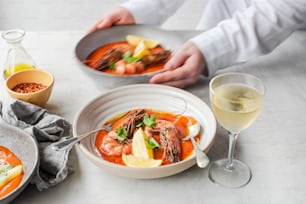 a table topped with bowls of food and a glass of wine