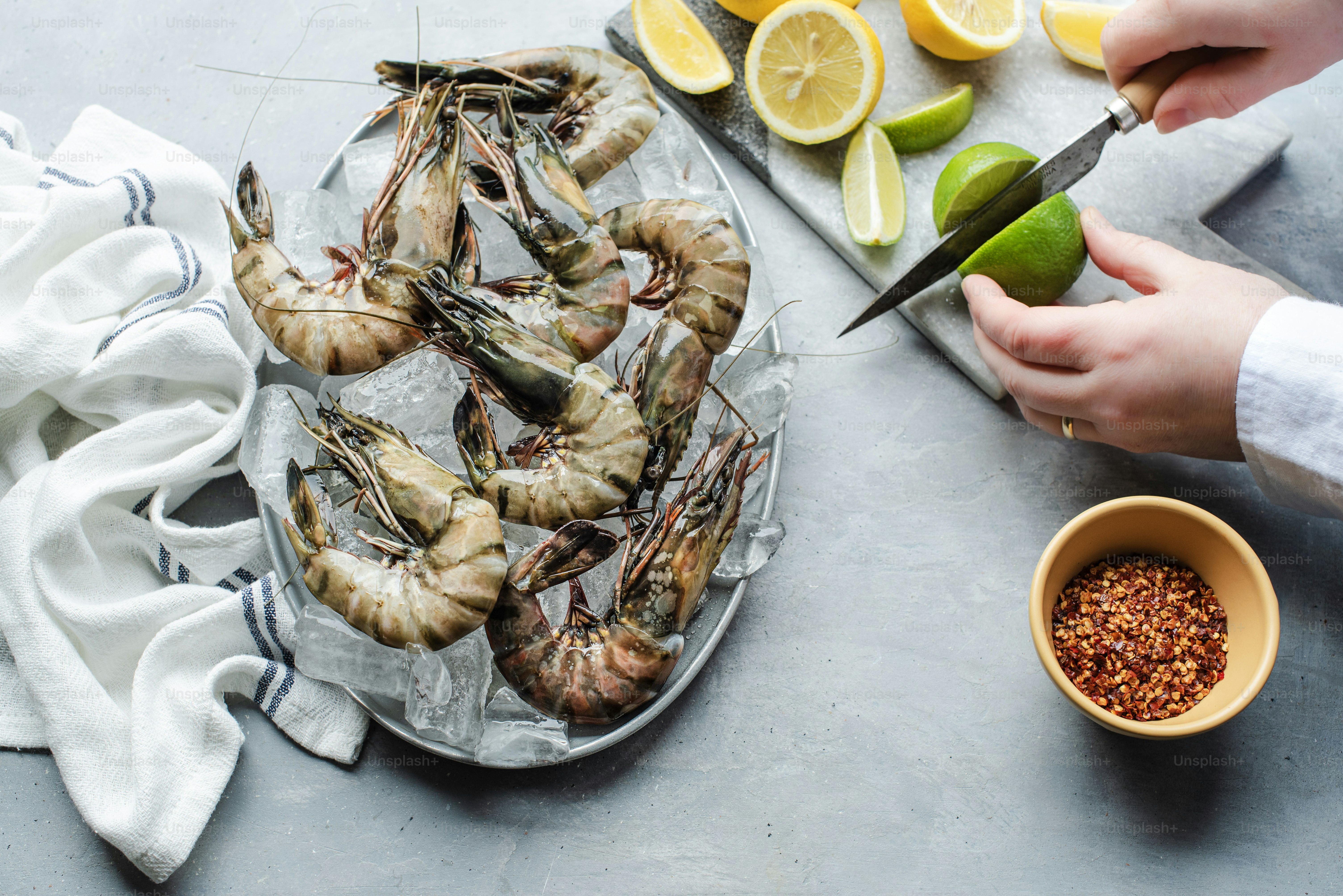 A person cutting up some shrimp on a plate photo – Cooking Image on ...