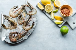 a plate of cooked shrimp next to a bowl of lemons and limes