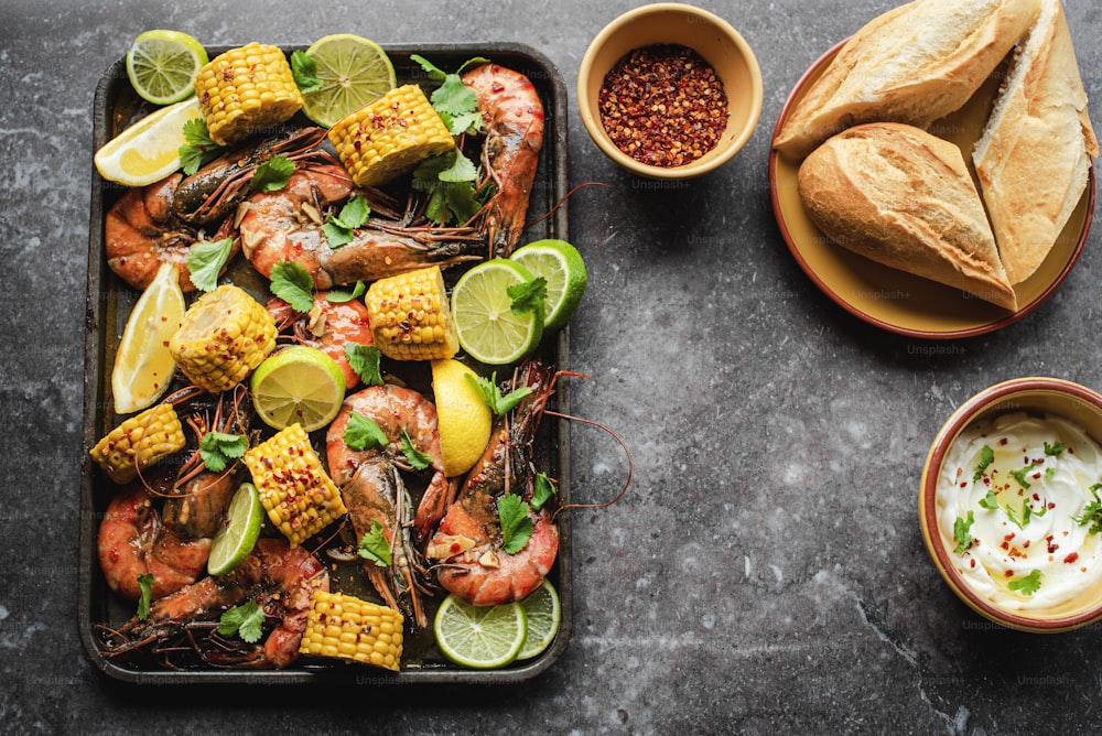 a tray of shrimp, corn, and corn on the cob