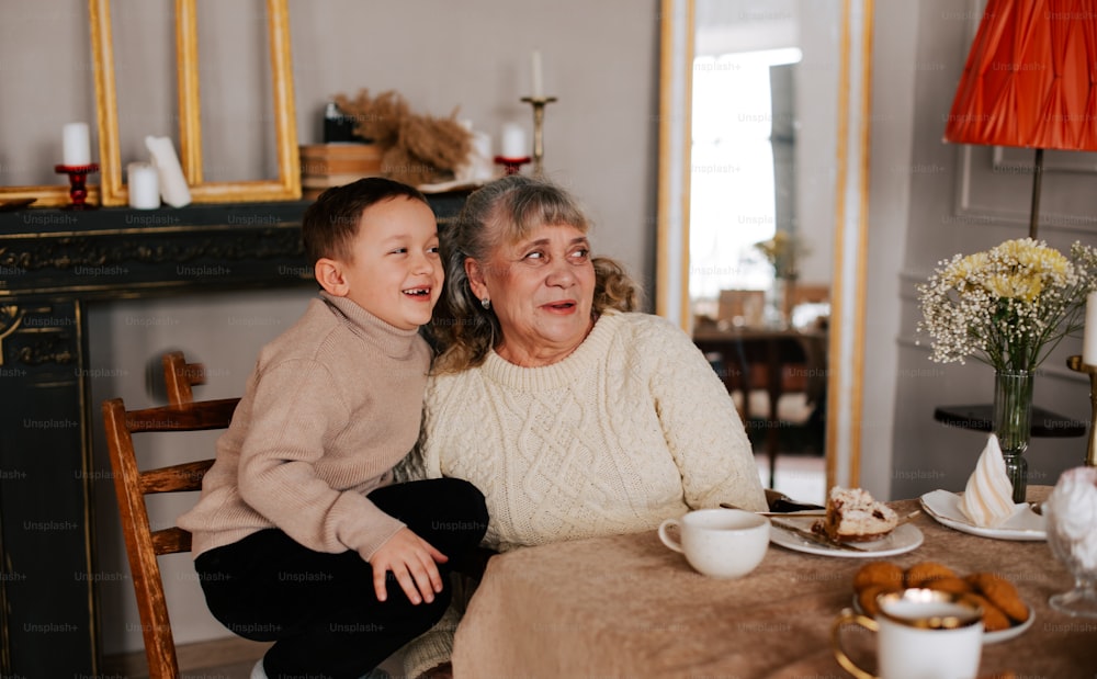 a woman sitting next to a child at a table