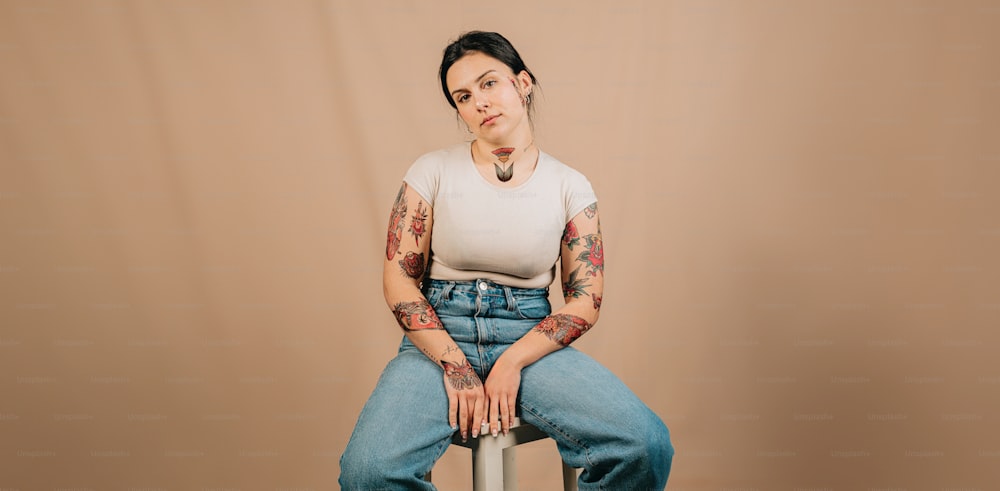 una mujer con tatuajes sentada en un taburete