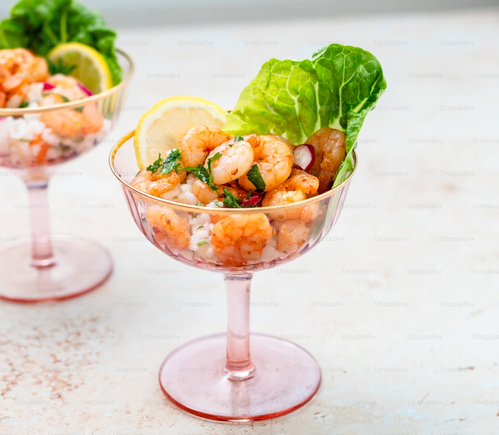 a couple of glasses filled with food on top of a table