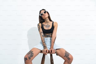 a woman with tattoos sitting on a chair