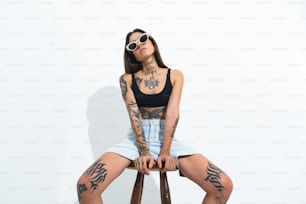 uma mulher com tatuagens sentada em uma cadeira