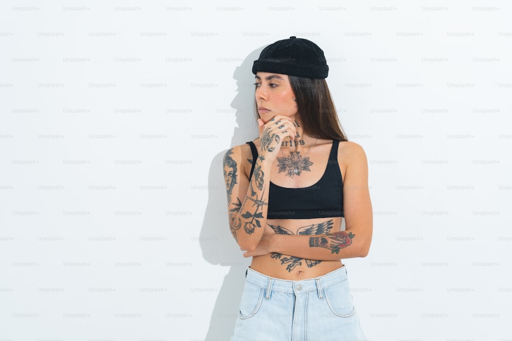 una mujer con tatuajes y un sombrero negro