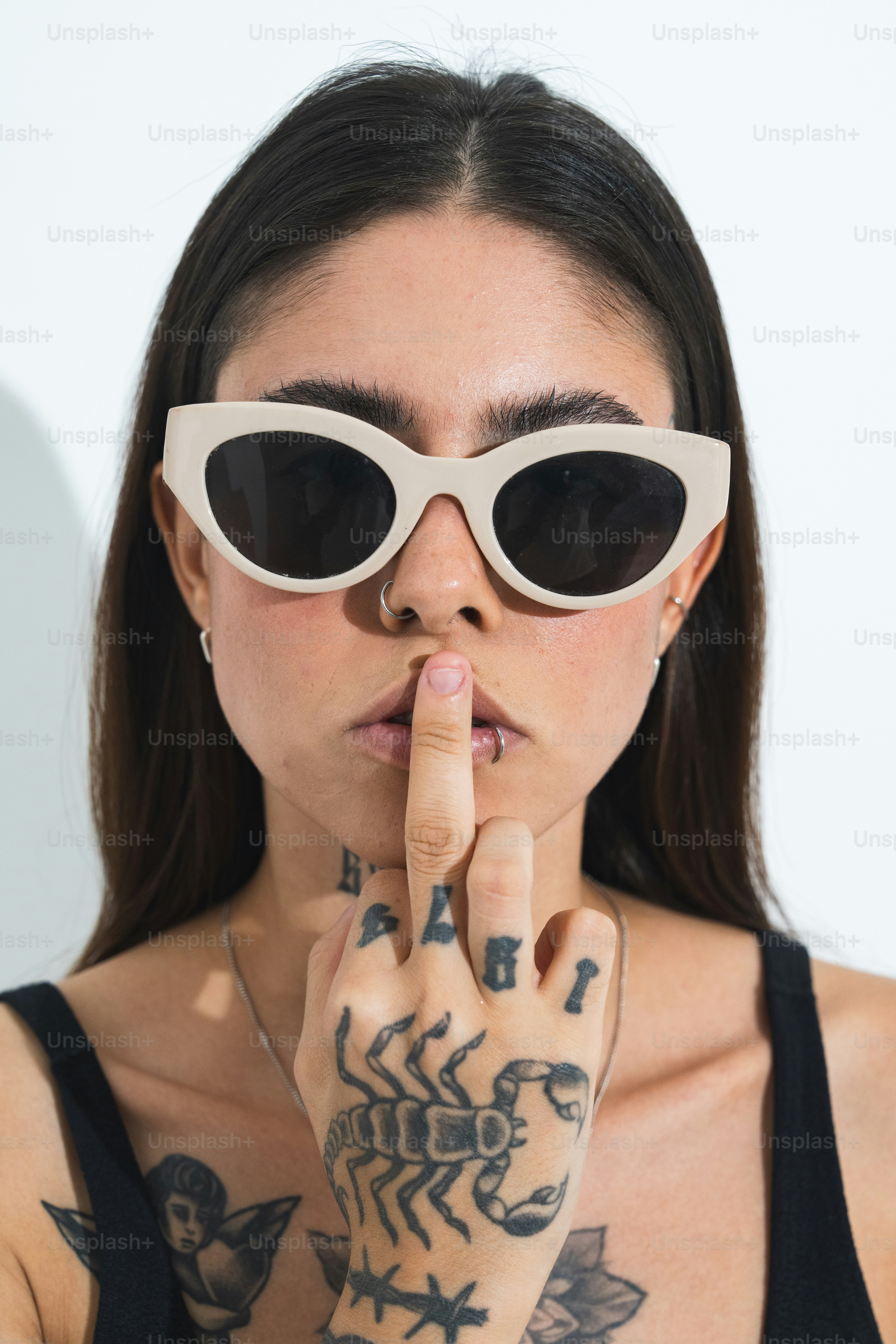 a woman wearing sunglasses making a finger sign