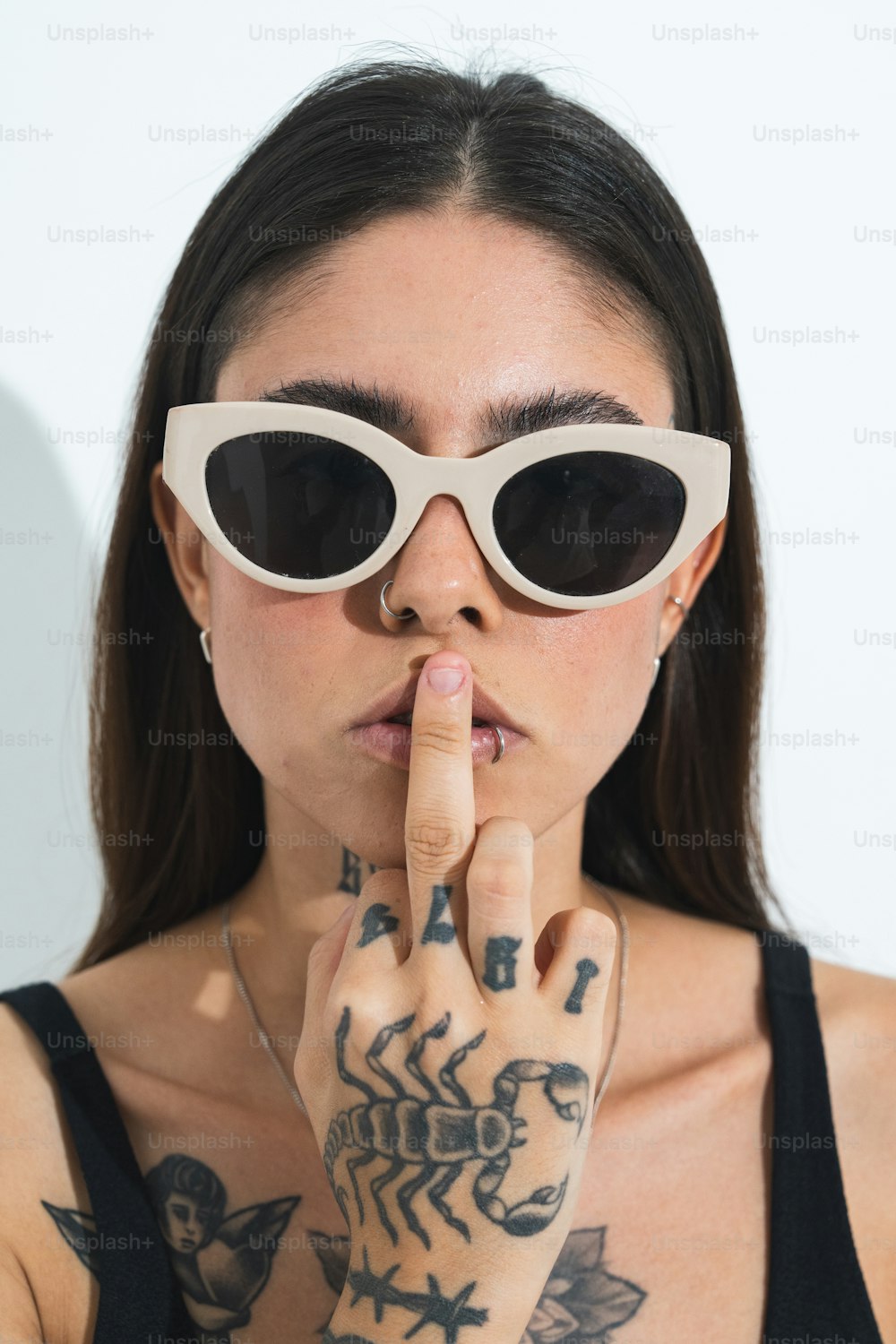 una mujer con gafas de sol haciendo un signo con el dedo