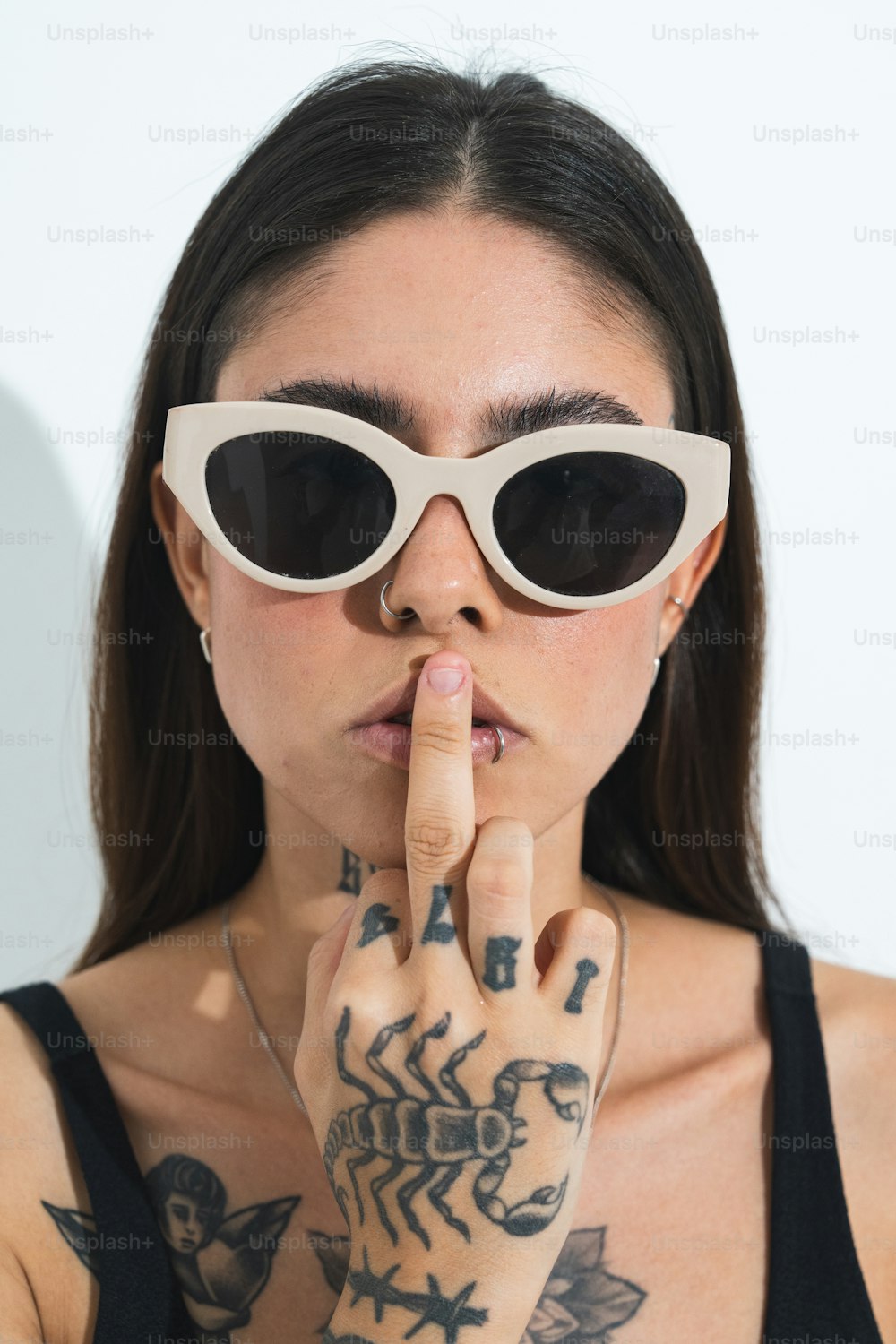 a woman wearing sunglasses making a finger sign