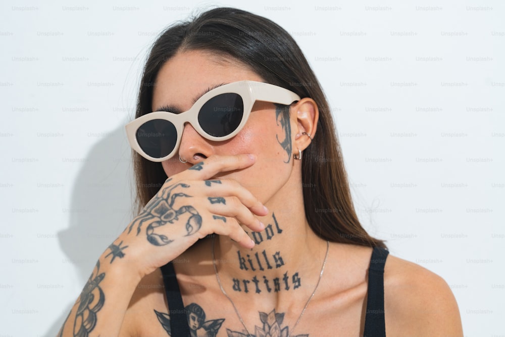 una donna con tatuaggi sul viso e occhiali da sole sul viso