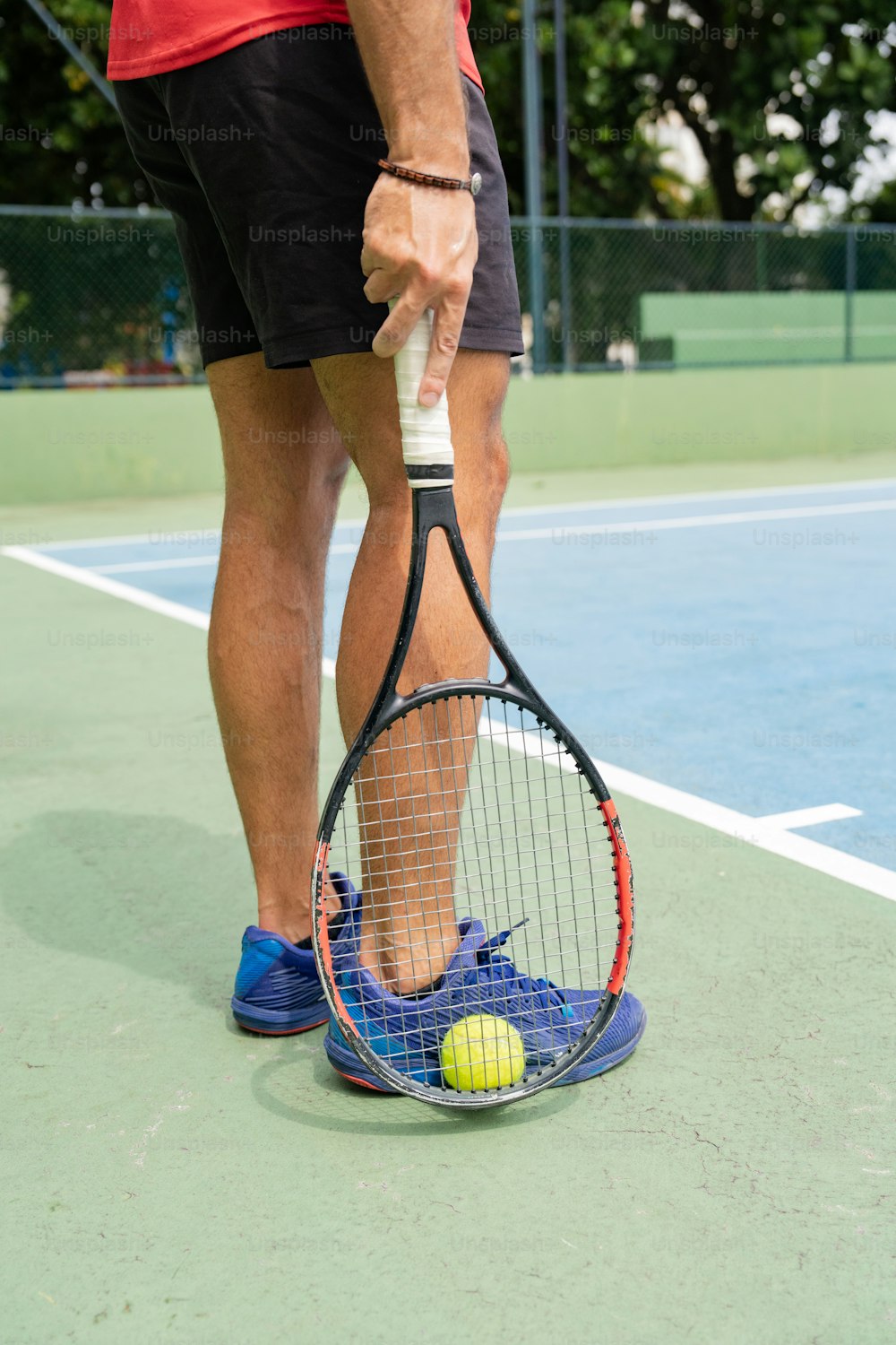 Un hombre sosteniendo una raqueta de tenis encima de una cancha de tenis