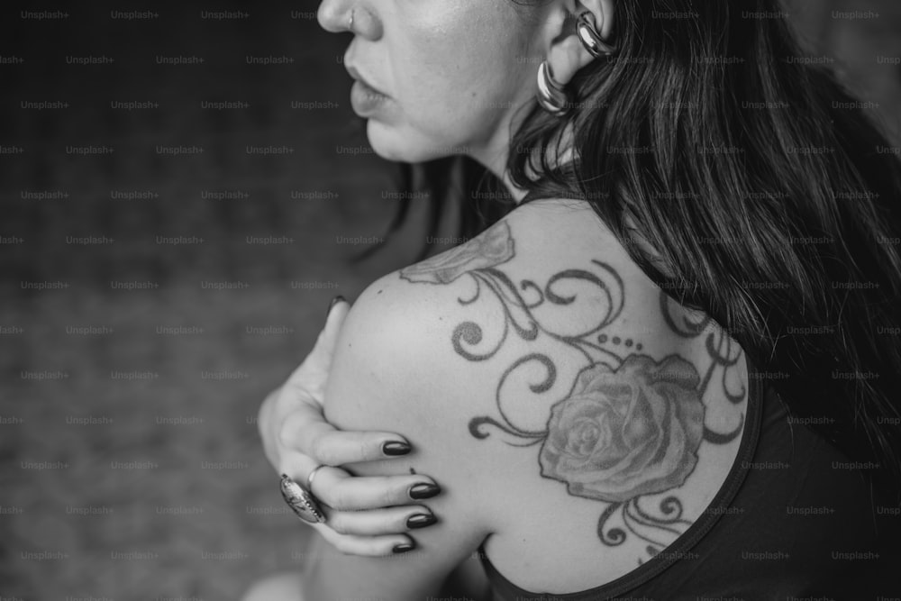 uma mulher com uma tatuagem de rosa no ombro