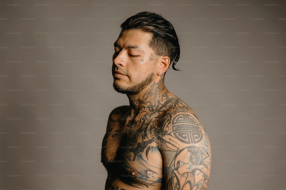 Ein Mann mit vielen Tattoos auf der Brust
