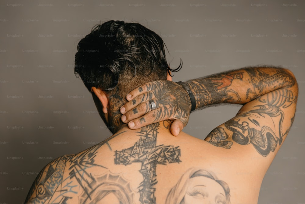 a man with a cross tattoo on his back