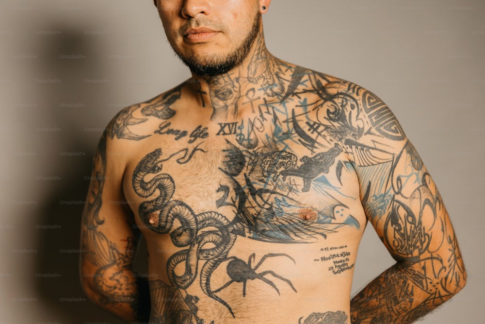 un uomo con un sacco di tatuaggi sul petto