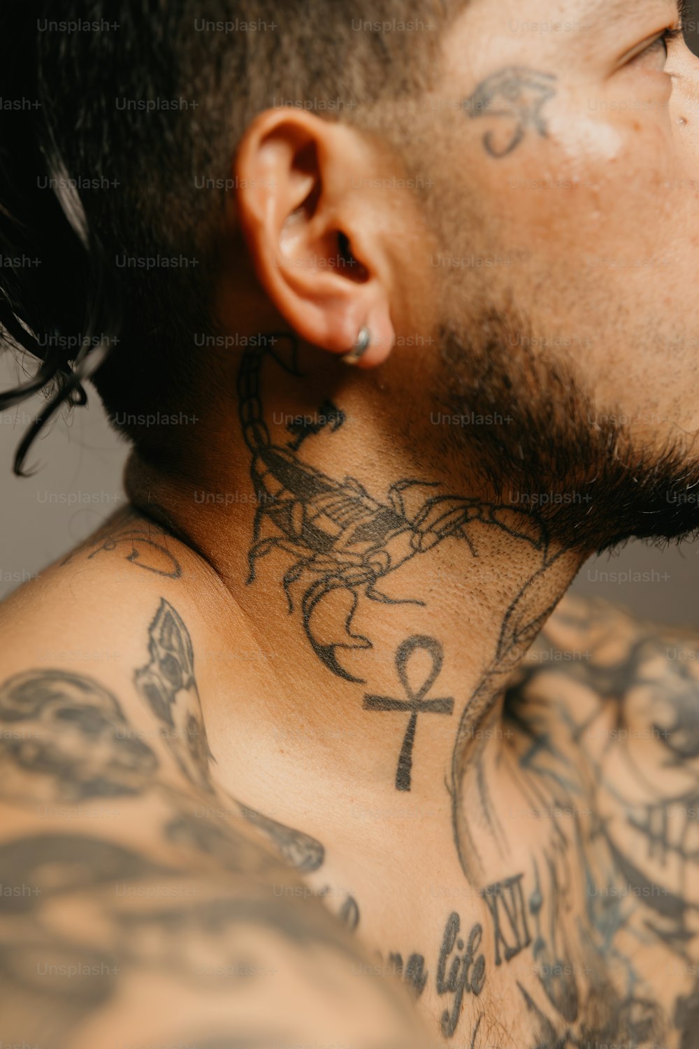 um close up de um homem com tatuagens no pescoço
