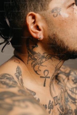 gros plan d’un homme avec des tatouages sur le cou