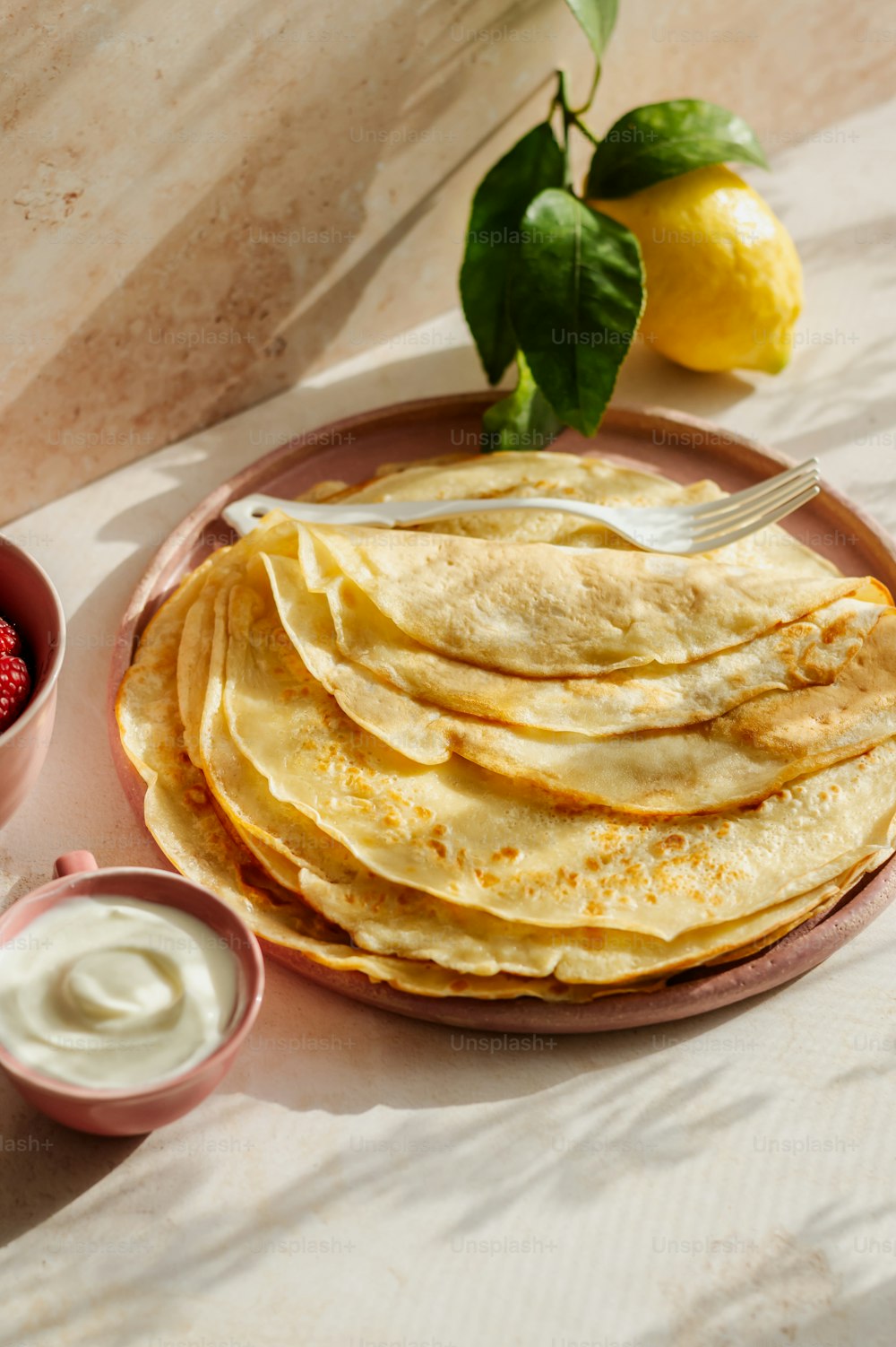 a plate of flatbreads and a bowl of yogurt