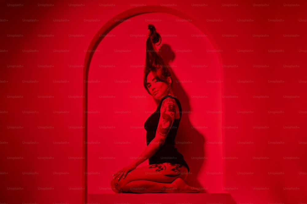una donna seduta su uno scaffale in una stanza rossa